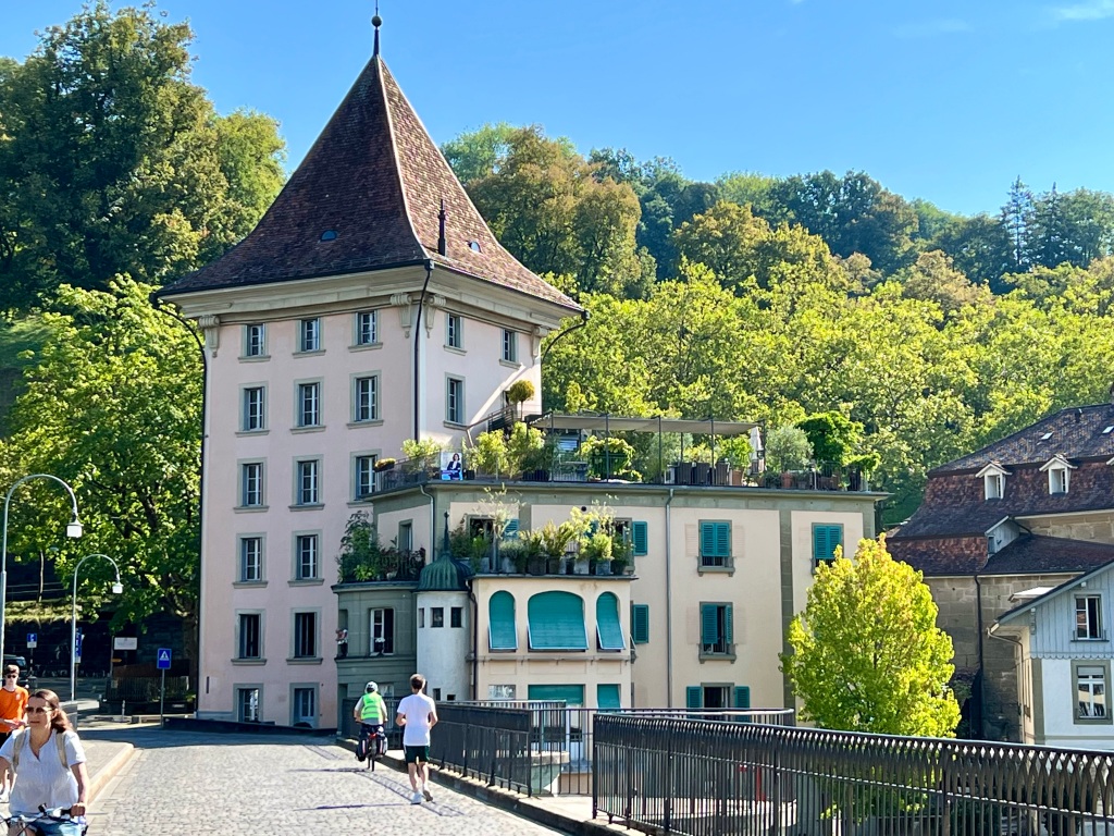 Tall Swiss style building with tress in background