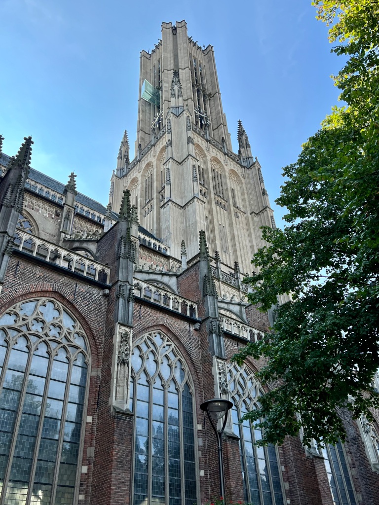 Arnhem cathedral, showing large glass windows and detailed stonemasonry.
