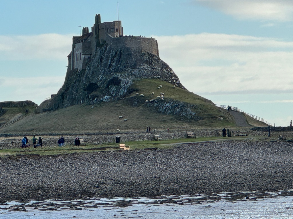 Photo of Lindisfarne Castle with stone beach in foreground
